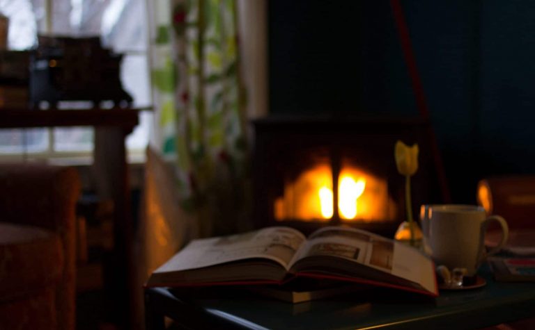 reading a book by a fireplace