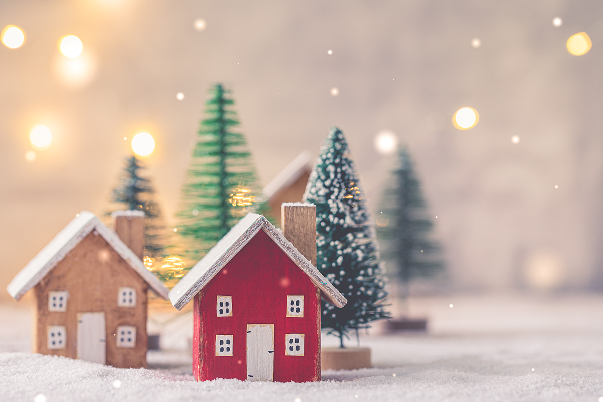 Miniature wooden houses over blurred Christmas decoration background